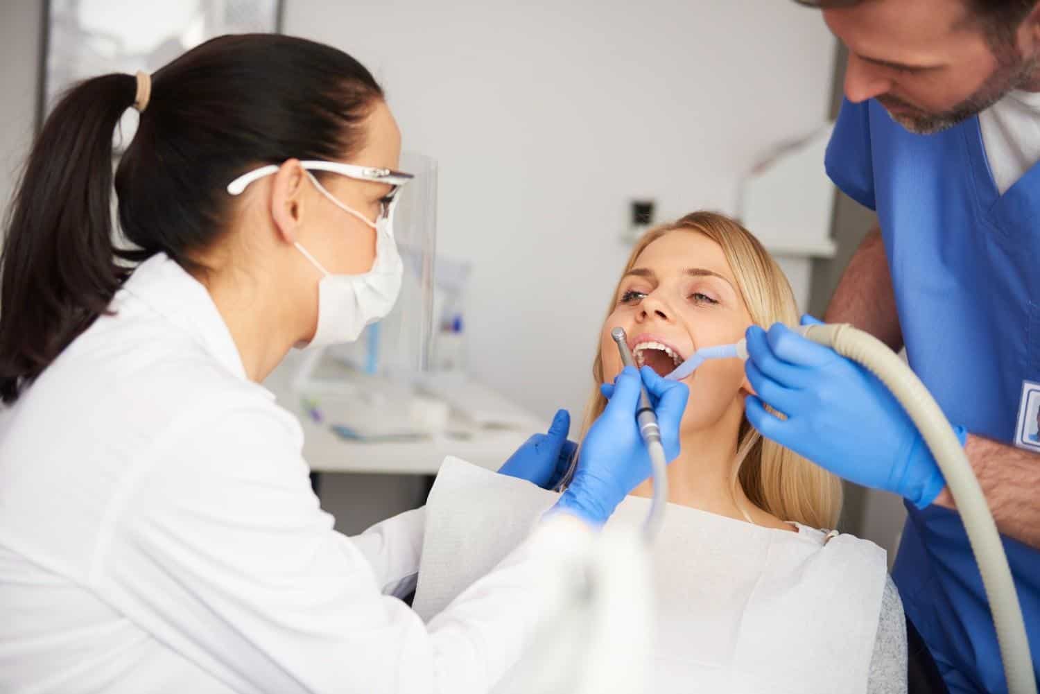 Dentista che esegue un trattamento endodontico su una paziente in clinica.