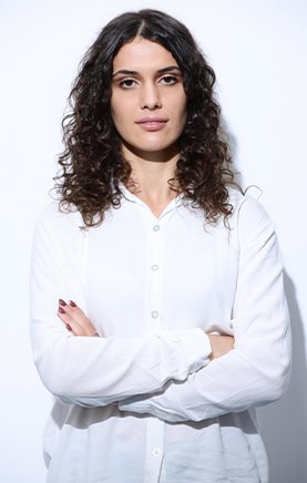 Dentista sorridente con braccia incrociate, in studio odontoiatrico, pronto ad aiutare i pazienti.
