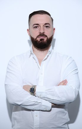 Dentista sorridente con braccia incrociate, in studio odontoiatrico, pronto ad aiutare i pazienti.