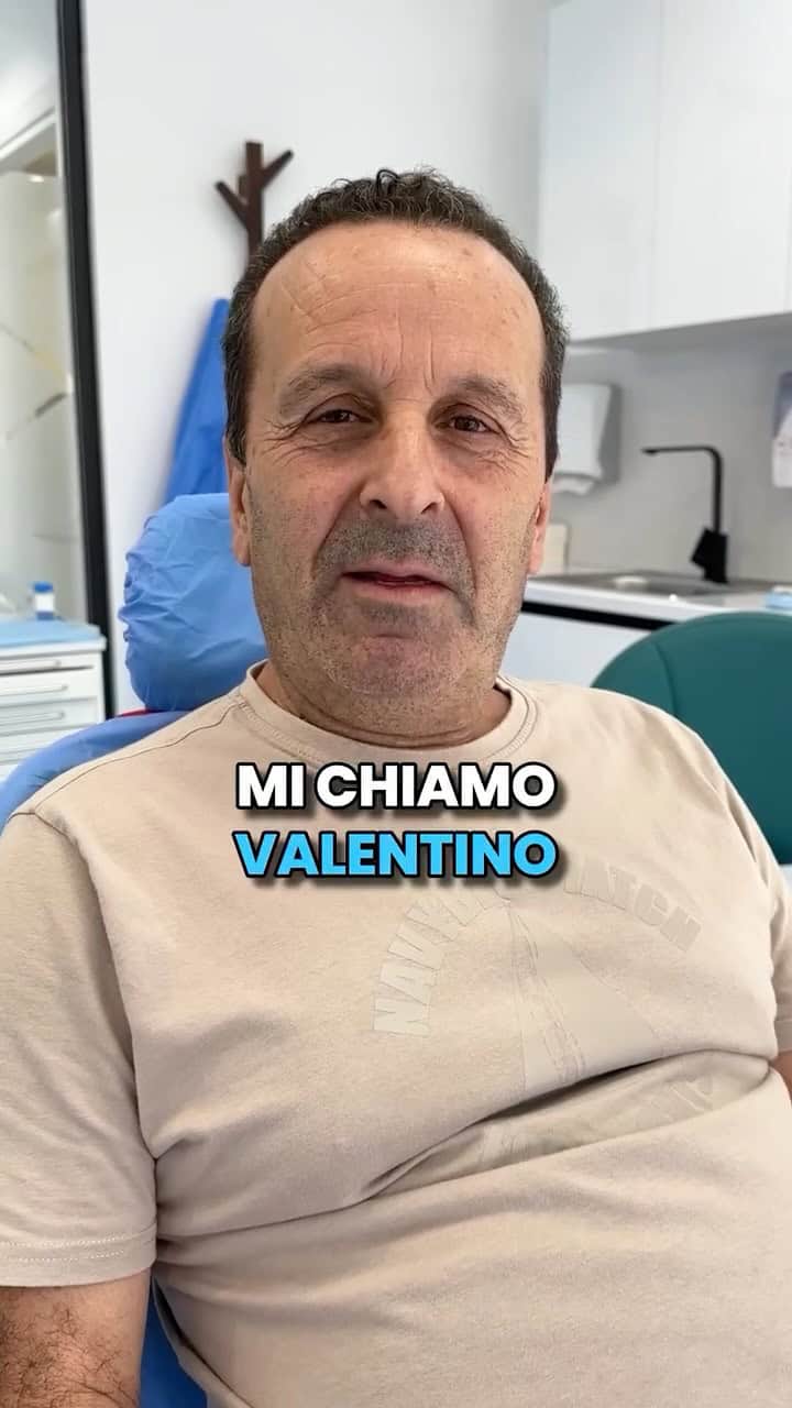 Dentista en Albania con bata beige, sentado en un consultorio dental.