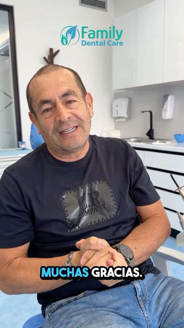 Hombre sonriente en una clínica dental con el logo de Family Dental Care al fondo.