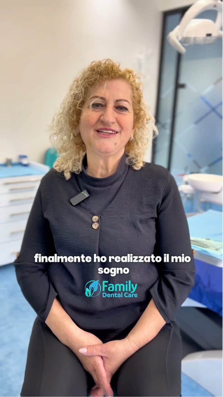 Donna sorridente in studio dentistico con attrezzature moderne sullo sfondo.