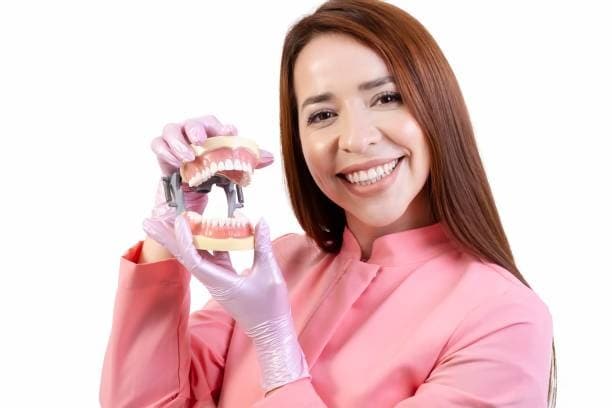 Dentista con modello di dentiera per riabilitazione orale completa.