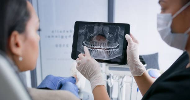 Radiografia dentale digitale mostrata a una paziente durante una visita odontoiatrica.