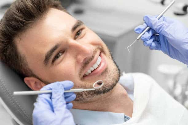 Paciente sorridente durante un trattamento di impianto dentale.