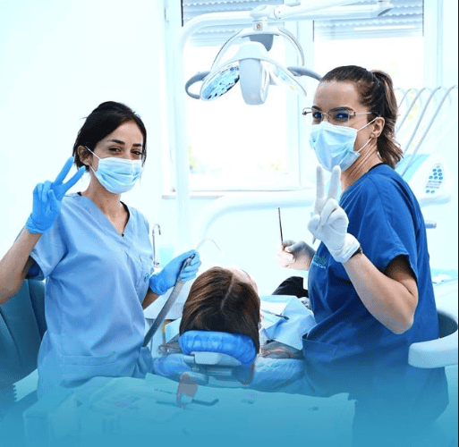 Due dentisti in mascherina e guanti durante trattamento odontoiatrico.