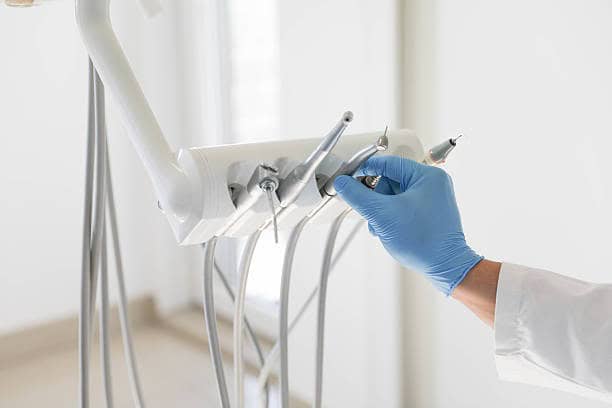 Operatore dentale con strumenti odontoiatrici in uso.