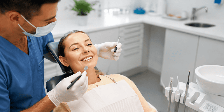Dentiste examinant et soignant une patiente souriante en cabinet.