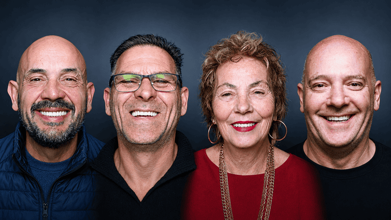 Gruppo di quattro persone sorridenti in primo piano.